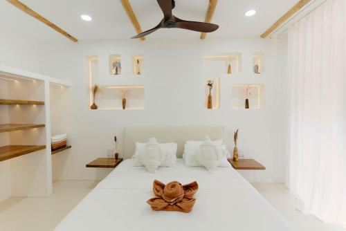 ein Schlafzimmer mit einem weißen Bett mit einer Schleife darauf in der Unterkunft Hoshi Villas in General Luna