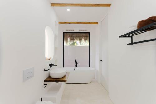 ein weißes Badezimmer mit Badewanne und Waschbecken in der Unterkunft Hoshi Villas in General Luna