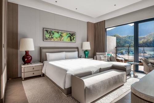 een slaapkamer met een groot wit bed en een bank bij InterContinental Maotai Town in Renhuai