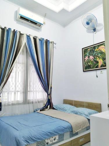 a bedroom with two beds and a window at Grities 7 Home Jogja in Yogyakarta