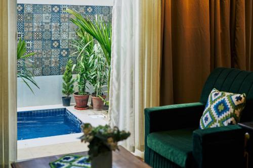 a living room with a swimming pool and a couch at Okka by Raho - A colonial style villa in Coorg in Siddapur