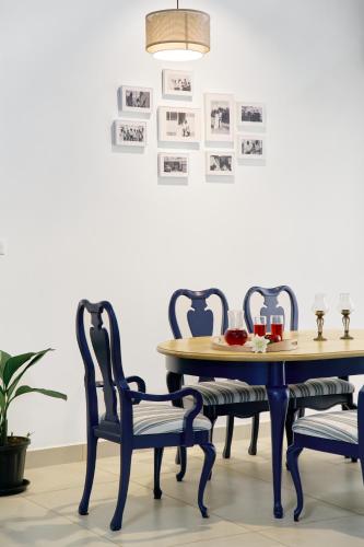 a dining room table with two chairs and a table with glasses on it at Okka by Raho - A colonial style villa in Coorg in Siddapur