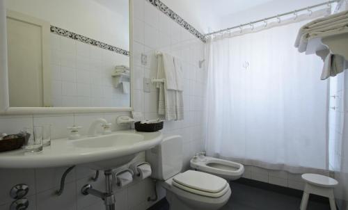 a white bathroom with a sink and a toilet at Solar De La Plaza in Salta