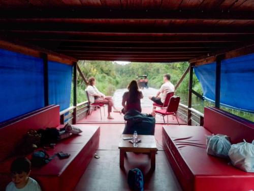 a group of people sitting on the deck of a boat at Orangutan Borneo Tour Tanjung Puting in Pangkalan Bun