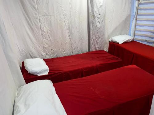 two beds in a room with red and white sheets at BE Happy Event Lounge in Mandaue City