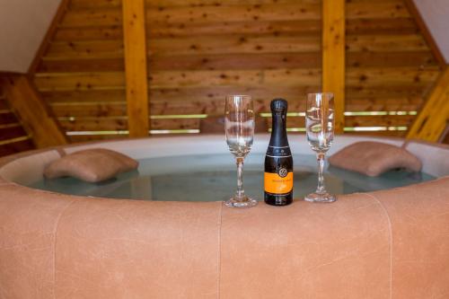a bottle of champagne and two wine glasses in a tub at Apartments Beeland Skok in Mozirje