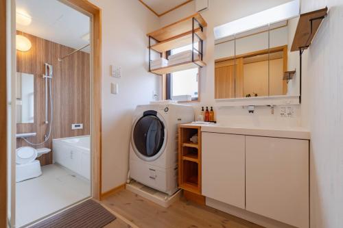a small bathroom with a washer and dryer at Villa Katarima 西軽井沢 in Miyota