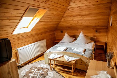 a bedroom with a bed in a wooden cabin at Casa dintre Pini Agapia in Agapia