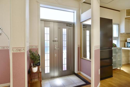 a hallway with a door with a window at 海徒歩1分アメリカンビレッジまで7分周辺には飲食店多数の北谷エリアSunabeNest in Chatan