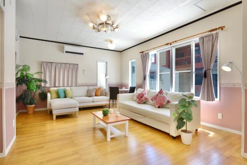 a living room with a couch and a table at 海徒歩1分アメリカンビレッジまで7分周辺には飲食店多数の北谷エリアSunabeNest in Chatan