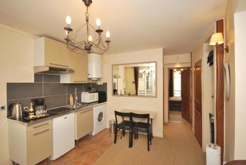 une cuisine avec une table et des chaises dans une pièce dans l'établissement Appartement Luxembourg-proche St Germain des prés, à Paris