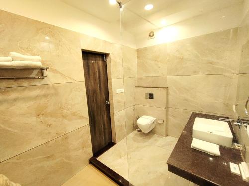 ein Badezimmer mit Toilette und Glasdusche in der Unterkunft DL Resort Dhikuli Jim Corbett in Garjia