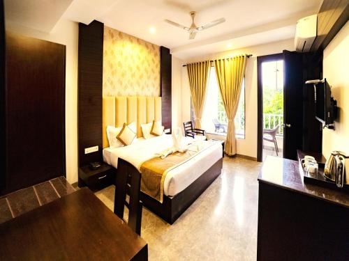 ein Hotelzimmer mit einem Bett und einem Fernseher in der Unterkunft DL Resort Dhikuli Jim Corbett in Garjia