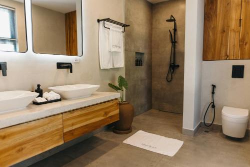 een badkamer met 2 wastafels en een toilet bij Johari Beach Resort, Kizimkazi Zanzibar in Kizimkazi