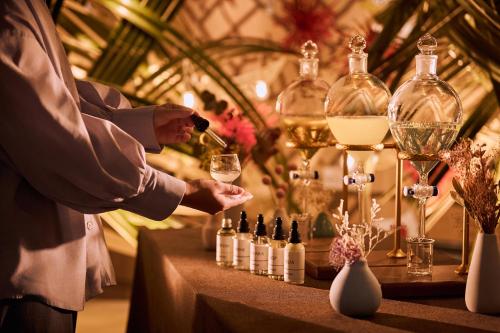 a man is holding a glass of wine on a table at OMO3 Tokyo Akasaka by Hoshino Resort in Tokyo