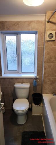 ein Badezimmer mit Toilette und Waschbecken und einem Fenster in der Unterkunft Peaceful Family Home in Tilbury with Garden Parking for 3 Cars in Low Street