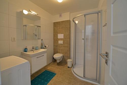 a bathroom with a shower and a toilet and a sink at Apartmány Belveder in Hlohovec