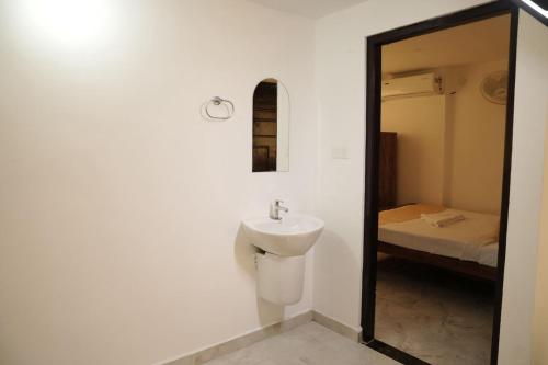 une salle de bain avec un lavabo et un miroir dans l'établissement Rajdhani Hospitality, à Kazhakuttam