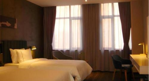 a hotel room with two beds and two windows at Ease Hotel Xi'an High-tech Zone 4th Zhangba Road Metro Station in Xi'an