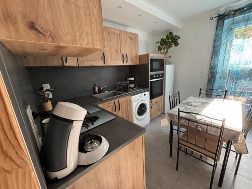 a kitchen with wooden cabinets and a table and a kitchen sidx sidx sidx at Gîte cosy avec jardin in Nyons