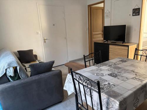 a living room with a couch and a table at Gîte cosy avec jardin in Nyons