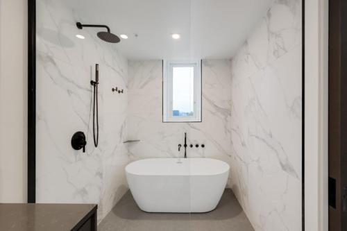 un bagno con una vasca bianca e un lavandino di Corporate Stays The Wedge Studio a Victoria