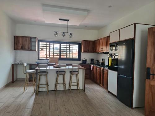 a kitchen with wooden cabinets and a black refrigerator at PalissHotel in Faravohitra