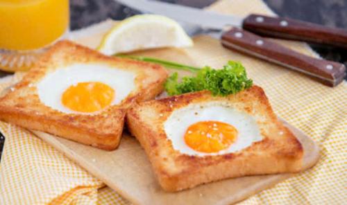 2 Stück Toast mit Eiern auf einem Schneidebrett in der Unterkunft Tamcoc Athletic Bungalow & Restaurant in Ninh Bình