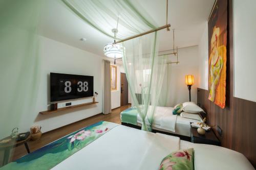 a bedroom with two beds and a clock on the wall at Xi'an Da Tang Yin Courtyard Hotel in Xi'an
