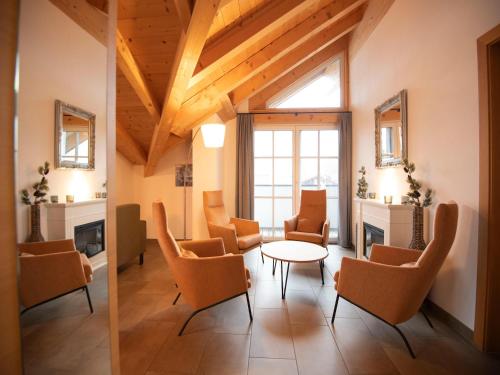 a living room with orange chairs and a table at Luxury penthouse with Balcony, Ski Storage, Carport, Lift in Brixen im Thale