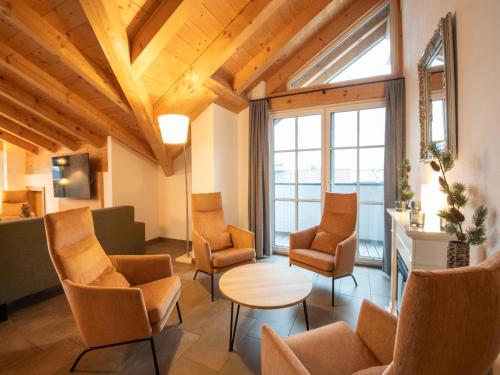 a living room with chairs and a table and windows at Luxury penthouse with Balcony, Ski Storage, Carport, Lift in Brixen im Thale