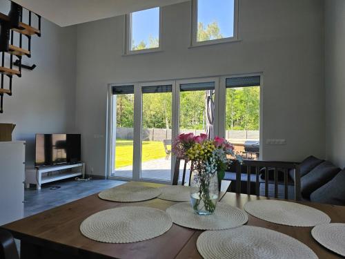 a living room with a table with a vase of flowers at Leśny Zakątek Świączyń 