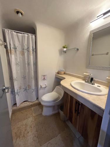 a bathroom with a toilet and a sink and a mirror at Blue angel 24 in Playa del Carmen