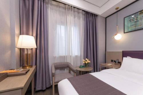 Postel nebo postele na pokoji v ubytování GYA Jiaxing Tongxiang City Century Avenue Hotel