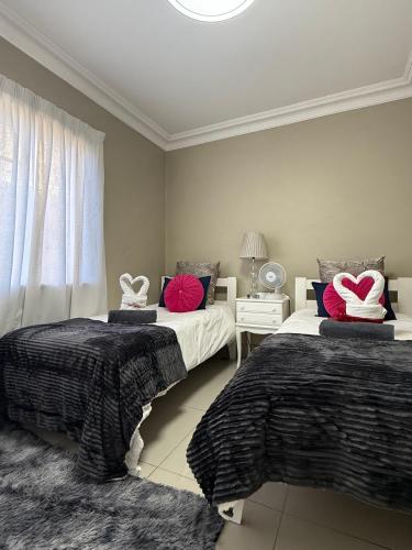 a bedroom with two beds with pillows on them at The Ocean Nook - Modern Beach Condo in Gqeberha