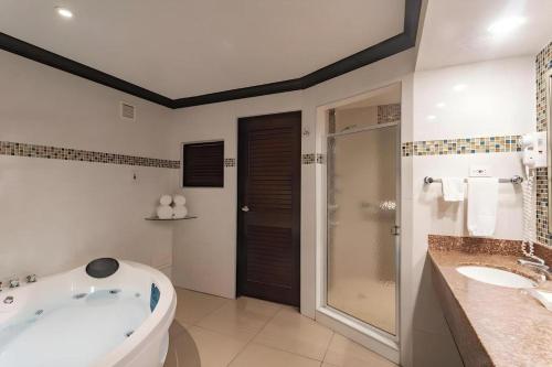a bathroom with a tub and two sinks and a shower at Catalonia Montego Bay - All Inclusive in Montego Bay