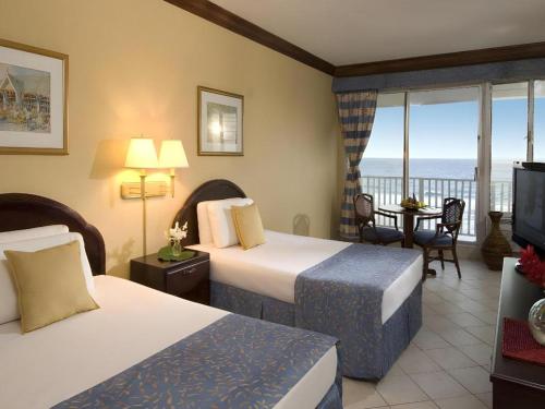 una camera d'albergo con due letti e vista sull'oceano di Catalonia Montego Bay - All Inclusive a Montego Bay