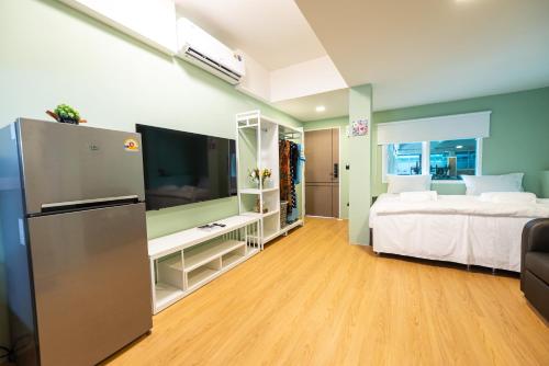 a bedroom with a bed and a tv in a room at GL Sport Club Serviced Residence in Bangkok
