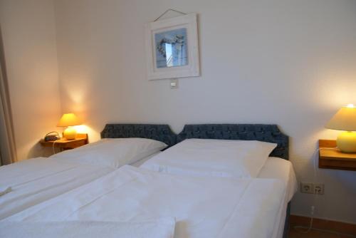 2 lits dans une chambre d'hôtel avec 2 lampes sur les tables dans l'établissement Ferienwohnung im Haus Katharina, à Lauterbach