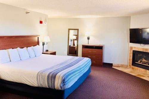 a hotel room with a bed and a fireplace at AmericInn by Wyndham Stillwater in Stillwater