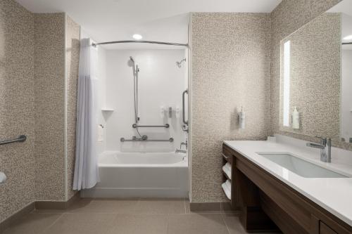 シンシナティにあるHome2 Suites By Hilton Cincinnati Eastgateの浴槽、洗面台、シャワーを備えたバスルーム