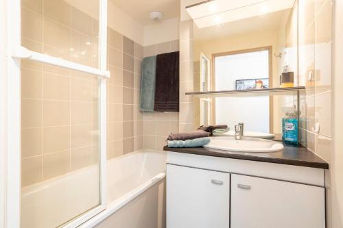 オーディエルヌにあるAppartement duplex vue merの洗面台、浴槽、シャワーを備えたバスルーム