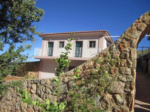a house with a stone wall in front of it at Santa Xenia in Galaxidhion
