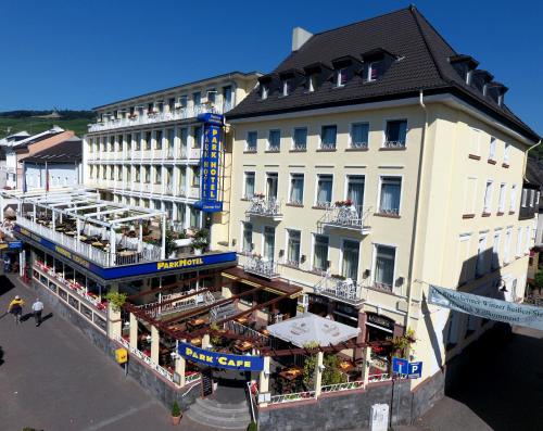 widok na hotel ze stołami i parasolami w obiekcie Parkhotel Rüdesheim w mieście Rüdesheim am Rhein