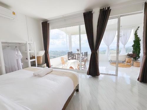 a bedroom with a bed and a large window at Keeree Farm คีรีฟาร์ม ดอยช้าง ที่พักบนดอยช้าง in Ban Huai Khai