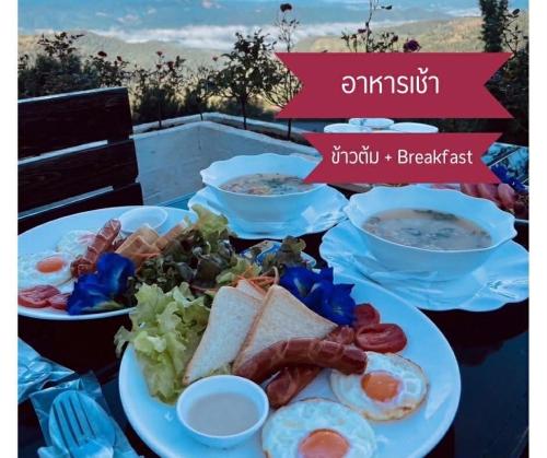 a table with plates of breakfast food on it at Keeree Farm คีรีฟาร์ม ดอยช้าง ที่พักบนดอยช้าง in Ban Huai Khai
