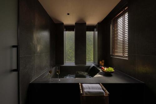 a black bathroom with a tub and a window at Shan shang shan HOTEL in Mount Siguniang