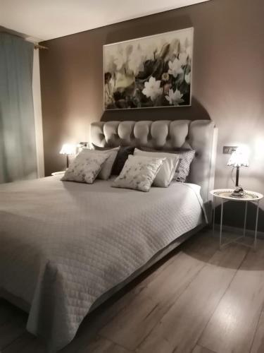 a bedroom with a white bed with a painting above it at Few Steps to the Bay in Jūrmala