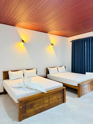two beds in a room with lights on the ceiling at Sigiri Thaniya Villa in Sigiriya