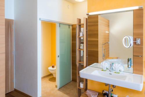 a bathroom with a sink and a toilet at Hotel Walserberg in Warth am Arlberg